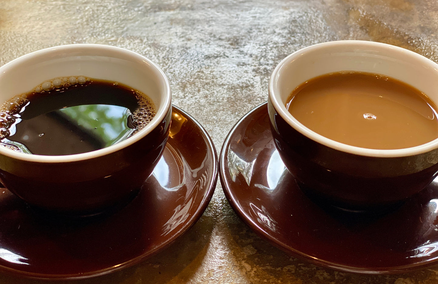 Two Cups Of Coffee One Black and One With Cream